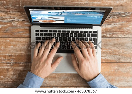 business, mass media, people and technology concept - close up of male hands typing on laptop with news web site on screen
