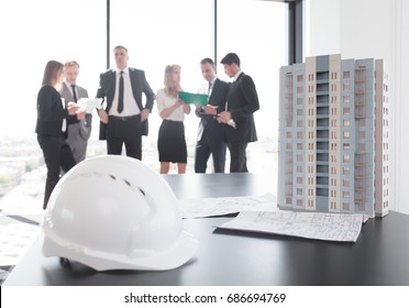 Business Meeting Of Architects And Investors, Model Of Modern Multi Storey Residential Building House And Hardhat On Table