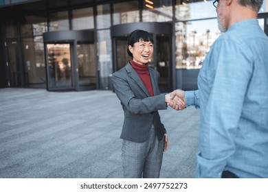 Business meeting between Japanese woman and mature caucasian man outdoors - Powered by Shutterstock