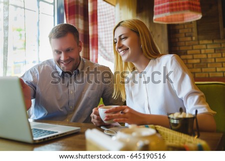 Business meeting in a cafe. happy or successful Man and woman Looking at tablet