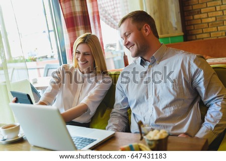 Business meeting in a cafe. happy or successful Man and woman Looking at tablet