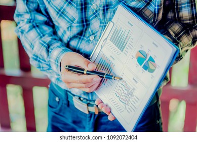 Business meeting, man's hands pointing on charts. Reflection light and flare. Concept image of data gathering and statistical working.