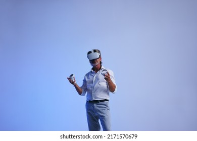 Business Meeting In The Metaverse. Senior Businessman Giving A Presentation Using Virtual Reality Technology. Mature Businessman Communicating With His Colleagues Using 3D Simulation.