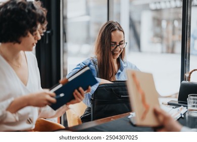 A business meeting in a modern coffee shop where people use technology to analyze reports, brainstorm ideas, and strategize for sales and marketing growth. - Powered by Shutterstock