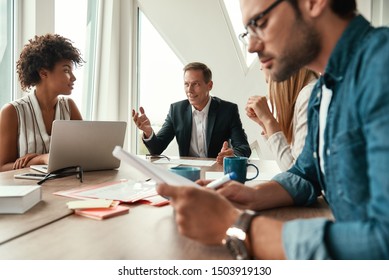 Business Meeting. Multicultural Team Discussing New Project While Sitting At The Office Table