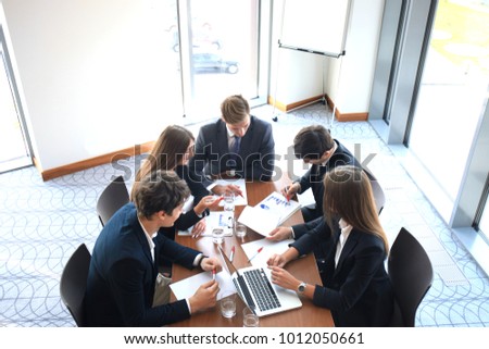 Business meeting in an office, the businesspeople are discussing a document.