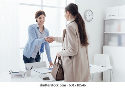 Business Meeting In The Office, A Businesswoman Is Giving An Handshake To The Customer; Job Interview And Agreement Concept