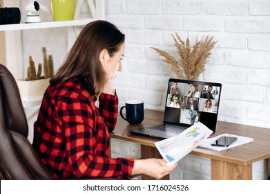 Business meeting online. Business team working from home in a video conference. The girl communicates via video call communication using laptop with her business colleagues about business strategy - Shutterstock ID 1716024526