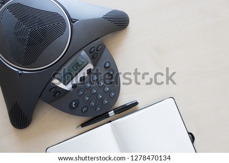 Business meeting room with conference phone directly from the above, conf call message on display
