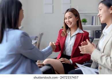 Business meeting success. Professional women shaking hands, smiling, discussing deal in modern office. Partnership, collaboration, teamwork. - Powered by Shutterstock