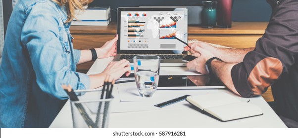 Business Meeting. Teamwork. Businessman And Businesswoman Sitting At Table In Front Of Laptop And Working. Man Shows Pencil On Computer Screen.Graphs,charts And Diagrams On PC Screen.Online Education.