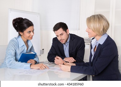 Business Meeting. Three People Sitting At The Table In An Office.