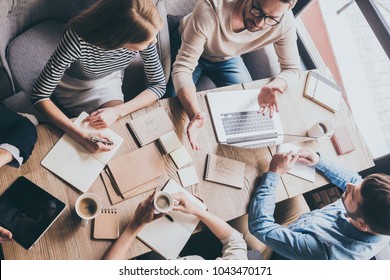 Business meeting. Top view of buiness team brainstorming while sitting at the office table together - Shutterstock ID 1043470171