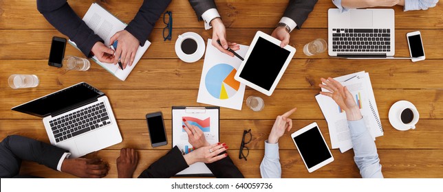 Business meeting top view. Multiethnic busy people work in office - Powered by Shutterstock