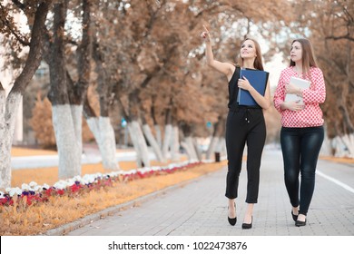 Business Meeting Of Two Girls In An Autumn Park
