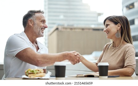 Business Meetings Made Better Over Lunch. Shot Of Two Businesspeople Shaking Hands While Having Lunch Outside An Office.