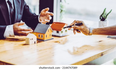 Business meetings of real estate brokers and company presidents to select a model to build a housing estate in writing and presenting to state organizations. - Shutterstock ID 2144747089