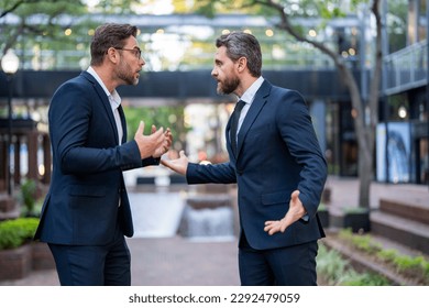 Business men aggressive fight outdoor. Conflict and fight business concept. Colleagues disputing having disagreement, diverse coworkers having conflict fight. Bad entrepreneurship. - Shutterstock ID 2292479059