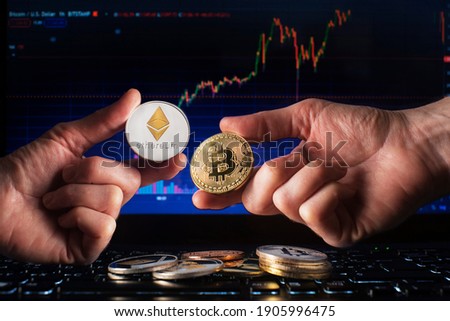 Business men holding bitcoin and ethereum coin whit computer trading chart background. Bitcoin and altcoin the most important cryptocurrency concept