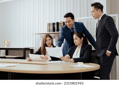 Business mentor meeting with team in office looking at document reports training management concept. Asian businesspeople work together with executive colleague group talking mentoring leadership idea - Shutterstock ID 2315801943