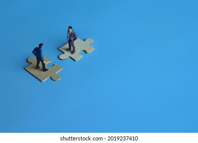 Business mergers and acquisitions, partnership concept. Two miniature people merging on puzzle. Copy space for text - Shutterstock ID 2019237410