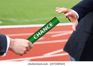 Business metaphor of passing the baton labeled Chance on the track field - Powered by Shutterstock