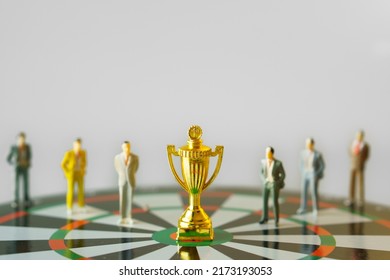 business miniature people standing around gold trophy on dartboard hitting in the target center of dartboard  Target business success and investment and finance concepts.