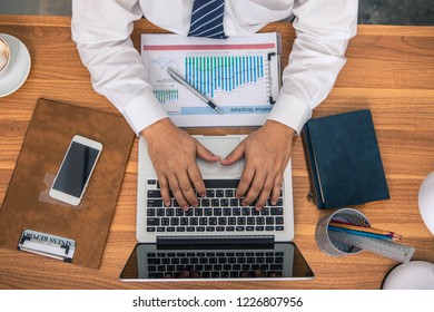 Business mna looking at computer monitor during working day in office. Businessman working on a laptop at office desk with other objects around, top view - Powered by Shutterstock