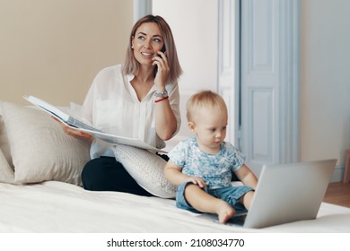 Business mom talking on a cell phone. Multi-tasking, freelance and motherhood concept