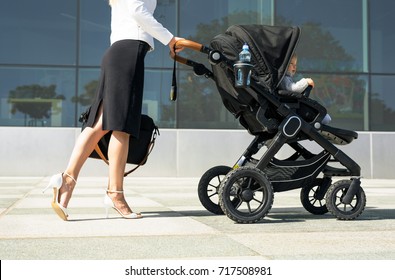 Business mother pushing baby on the way to work