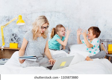 Business mum at work while her kids are playing in bed