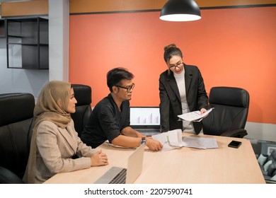 Business Muslim And Asian Woman And Man Have Meeting. Happy Fun Professional Employee Showing Team Present Company Project. Funny Beautiful Islam Person Laugh At Organization Plan In Conference Room.