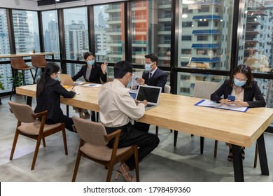 Business In New Normal. Office Workers Wearing Face Mask And Protection While Having Internal Meeting For New Business Strategy Or Plan. Technology For Social Distancing And New Normal