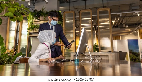 Business In New Normal. Young Muslim Lady Is Getting Support From Her Supervisor How To Use Technology For Online Business In An Environmental Friendly Office