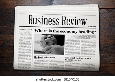 Business Newspaper on wooden background. - Shutterstock ID 381840133