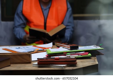 Business objects on background of  engineers discussing blueprint at in door (tool )