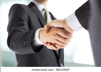 business and office concept - businessman shaking hands each oth