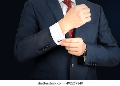 Business And Office Concept -  Elegant Young Fashion  Buisness Man In  A Blue/navy Suit Touching At His Cufflinks