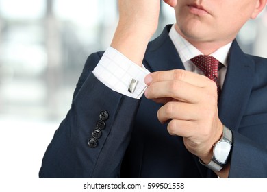 Business And Office Concept -  Elegant Young Fashion  Buisness Man In  A Blue/navy Suit Touching At His Cufflinks