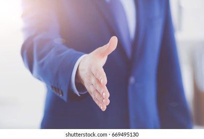 Business and office concept - handsome businessman with open hand ready for handshake - Shutterstock ID 669495130