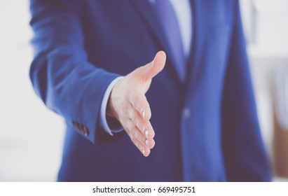 Business and office concept - handsome businessman with open hand ready for handshake - Shutterstock ID 669495751