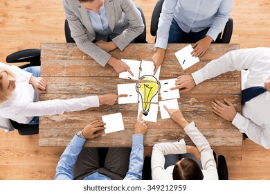business, office people, startup and teamwork concept - close up of creative team sitting at table and putting together puzzle pieces with light bulb picture - Shutterstock ID 349212959