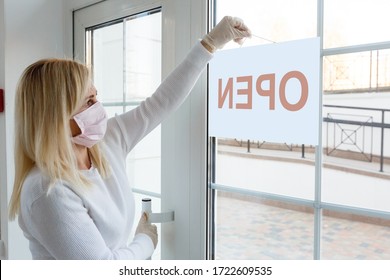 Business Office Or Store Shop Is Open Business Of Novel Coronavirus COVID-19 Pandemic. Unidentified Person Wearing Mask Hanging Open Sign In Background On Front Door.