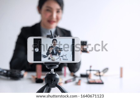 Business online on social media, Beautiful woman blogger is showing present tutorial beauty cosmetic product and broadcast live streaming video to social network while recording teaching online.