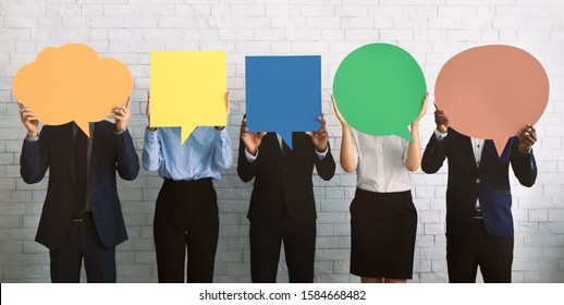 Business Opinion Concept. Group Of Corporate People Hiding Faces Behind Blank Speech Bubbles, Empty Space