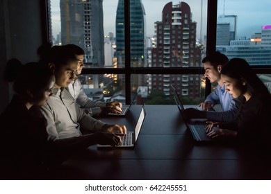 Business Overtime Concepts . Group Of Business People Working Overtime In Nighttime. Businessmen Are Serious About Office Work. Businessmen Working Late At Night After Work.