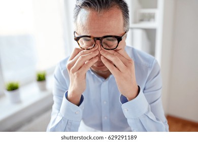 Business, Overwork, Deadline And People Concept - Close Up Of Tired Businessman In Eyeglasses Rubbing Eyes At Office