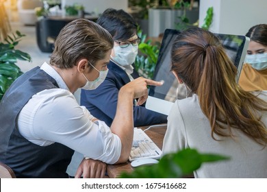 Business Owner Is Handsome, Wearing A Surgical Mask, Thinking Of Planning And Solving Business Problems With The Team  At Co Working Space Modern Office .Health And Teamwork Concept.
