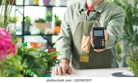 Business Owner In His Flower Shop, He Is Holding A POS Payment Terminal, Cashless Electronic Payments Concept