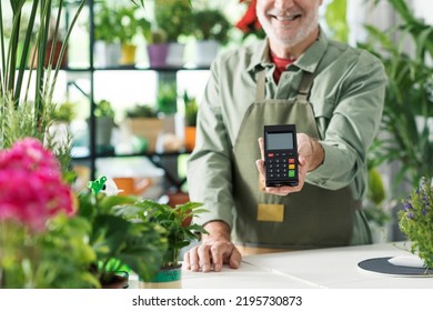 Business Owner In His Flower Shop, He Is Holding A POS Payment Terminal, Cashless Electronic Payments Concept